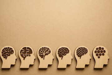 Poster - Wooden cutouts of human heads with different brain designs on a neutral background