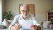 © Radorog. - An elderly man with glasses reads a paper document