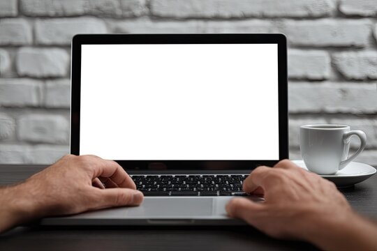 Laptop with blank screen, hands on keyboard, coffee