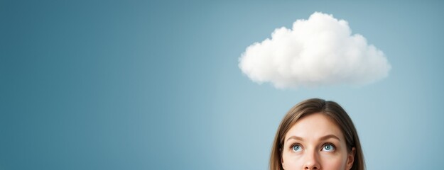 Poster - Thoughtful young woman looking up at a fluffy white cloud above her head on a bright blue background, concept of imagination and creativity.