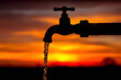 © utaem2022 - Water pouring from faucet at sunset symbolizing resource depletion