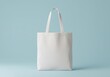 © Rehena - Plain white canvas tote bag against a light blue background for mockup design