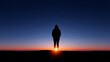 © pkproject - Silhouetted figure standing against a vibrant sunset horizon