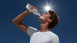 © Maksim Shebeko - A young man refreshes with water under the blazing sun, savoring the moment Generative AI