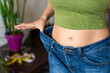 © Alfonso Soler - Woman showing weight loss wearing old jeans