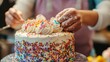 © Chotijah - An individual is decorating a cake with sprinkles and frosting