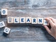 © Zander - Lifelong Learning and Knowledge Acquisition: Wooden Blocks Spelling 'LEARN' with Educational Icons