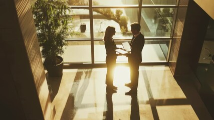 Poster - Business professionals engage in discussion while reviewing documents in a modern office environment, business people discussing documents standing in the office
