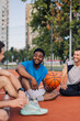 © Zamrznuti tonovi - Group of male basketball players relaxing on court after training