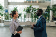 © Zamrznuti tonovi - Businesspeople talking in modern office lobby, discussing work strategy