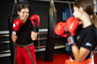 © JackF - Boy and a girl in red boxing gloves work in sparring, they practice punches and practice stance. Children's boxing and self-defense training