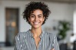 © Space Priest - Smiling young african female in striped shirt with curly hair indoors