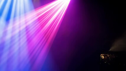 Poster - Illuminated beams of white, blue, and yellow spotlights shining upward into dark space create a colorful stage lighting effect.