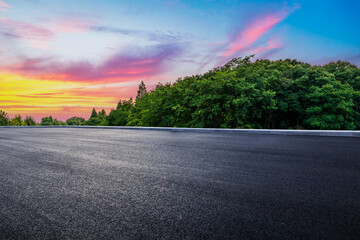 Wall Mural - empty asphalt road and green forest with beautiful sky clouds at sunset