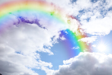 Wall Mural - bright rainbow in blue sky with clouds on sunny day