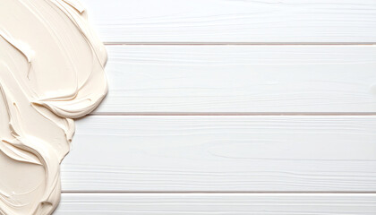 Poster - Smooth, creamy texture of pale paint on white wooden surface, creating a clean and artistic backdrop for creative projects