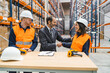 © Koldo_Studio - Manager shaking hands with a woman warehouse worker while finalizing a deal in a logistics center, with her colleague standing next to her