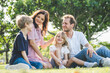 © Nopphon - Happy family parent children having picnic outdoor activity. Enjoy happiness moment summer playing together including father mother son and daughter relaxing in the morning sunrise.