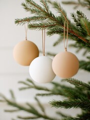 Poster - Three decorative round ornaments in neutral colors hanging from a pine tree branch indoors