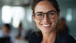 © standret - Smiling businesswoman with glasses in a modern office environment