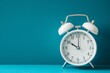 © Tati - White vintage alarm clock showing ten o'clock on turquoise blue background with copy space.