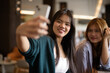 © Ranta Images - two women talking on the phone in a bar