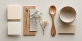 Flatlay of beige and off-white textured samples, wooden spoon and bowl, dried floral sprig, and linen fabric swatch
