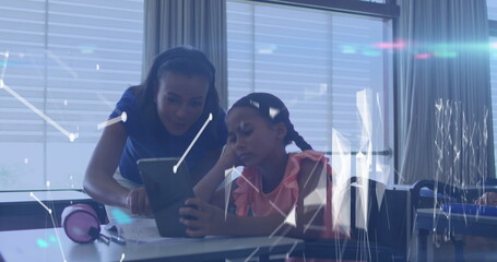 Poster - Collaborating teacher and student focusing on tablet screen at school desk, with pink headphones