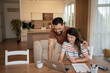 © Migma_Agency - Happy couple doing finances and calculating bills at home using laptop