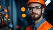 © JK_kyoto - Young male technician wearing safety glasses and orange helmet in industrial setting with machinery and glowing lights