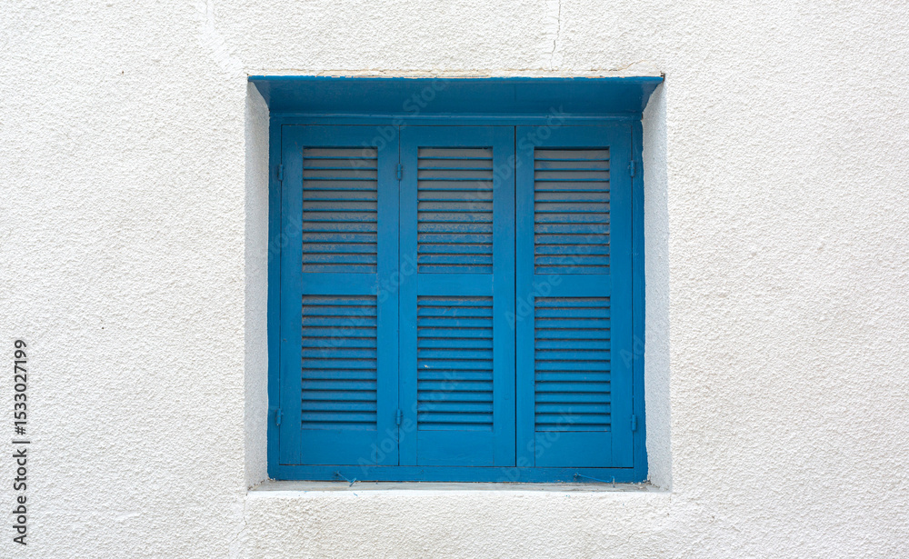 Bright blue window shutters decorating white wall in mediterranean ...