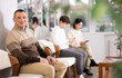 © JackF - Adult man sitting waiting in line on chair at reception