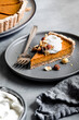 © The Picture Pantry - A slice of pumpkin pie topped with whipped cream and nuts on a gray plate with a fork.