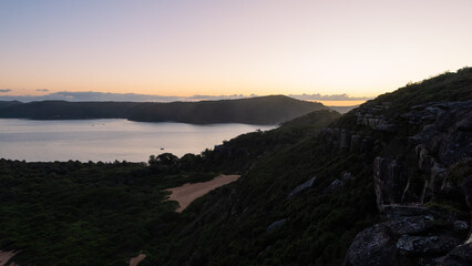 Wall Mural - Bay of water with coastal cliff around view.