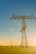 © neurobite - Beautiful farm landscape and industrial high voltage power line pylons and wind turbines farm at sunset warm colors and direct sun light with lens flare and sun rays in Germany