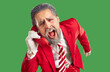 © Studio Romantic - Positive, crazy, stylish, young Santa Claus, dressed in classic stylish red suit, screams with his mouth open into the phone receiver. Studio photo close-up on isolated green background.