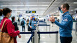 © catherine - Airport staff assisting passengers with facial recognition security