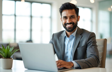 Aufkleber - smiling indian businessman works on laptop in modern office. man uses computer for video call. happy