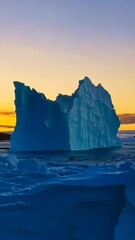 Wall Mural - majestic iceberg towering above tranquil waters at sunset, showcasing stunning blue hues and dramati