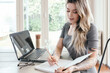 © Austockphoto - Young woman writing studying at home with pencil and notebook