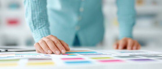 Poster - Person reviewing colorful charts and graphs on desk, focusing on data analysis