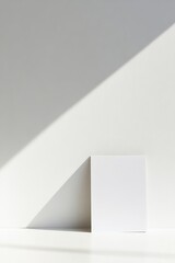 Aufkleber - Minimalist White Cube Casting a Shadow on a Bright Wall in a Serene Indoor Space During Daylight
