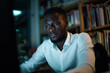 © Monktwins - A young African American man in a white shirt working on the computer, concentrated and focused on his work.