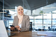 © Stock 4 You - Beautiful portrait of Middle Eastern muslim businesswoman manager ceo using cell phone mobile app. Smiling young indian woman in hijab holding smartphone sitting in office working online. Copy space