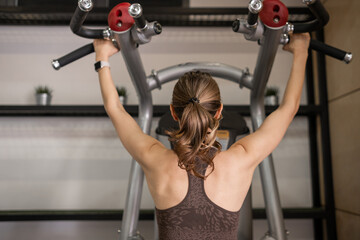 Poster - Woman Engaging in Strength Training at Gym With Fitness Equipment During Evening Workout Session
