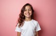 © Viktor - Young hispanic girl in white t-shirt stands before pink background. Cheerful smiling teen shows perfect teeth. Brunette woman with long wavy hair. Happy girl portrait for advertising, promo.