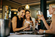 © Marko Geber - Group of businesswoman having wine in a cafe bar after work
