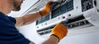 © AndiAzis - Male Technician Repairing White Air Conditioner Unit Indoors