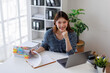 © David - Image of happy young Asian business woman working document and laptop at office