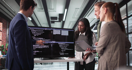 Fototapete - Software Developer Leading Late-Night Meeting With Programmer Team